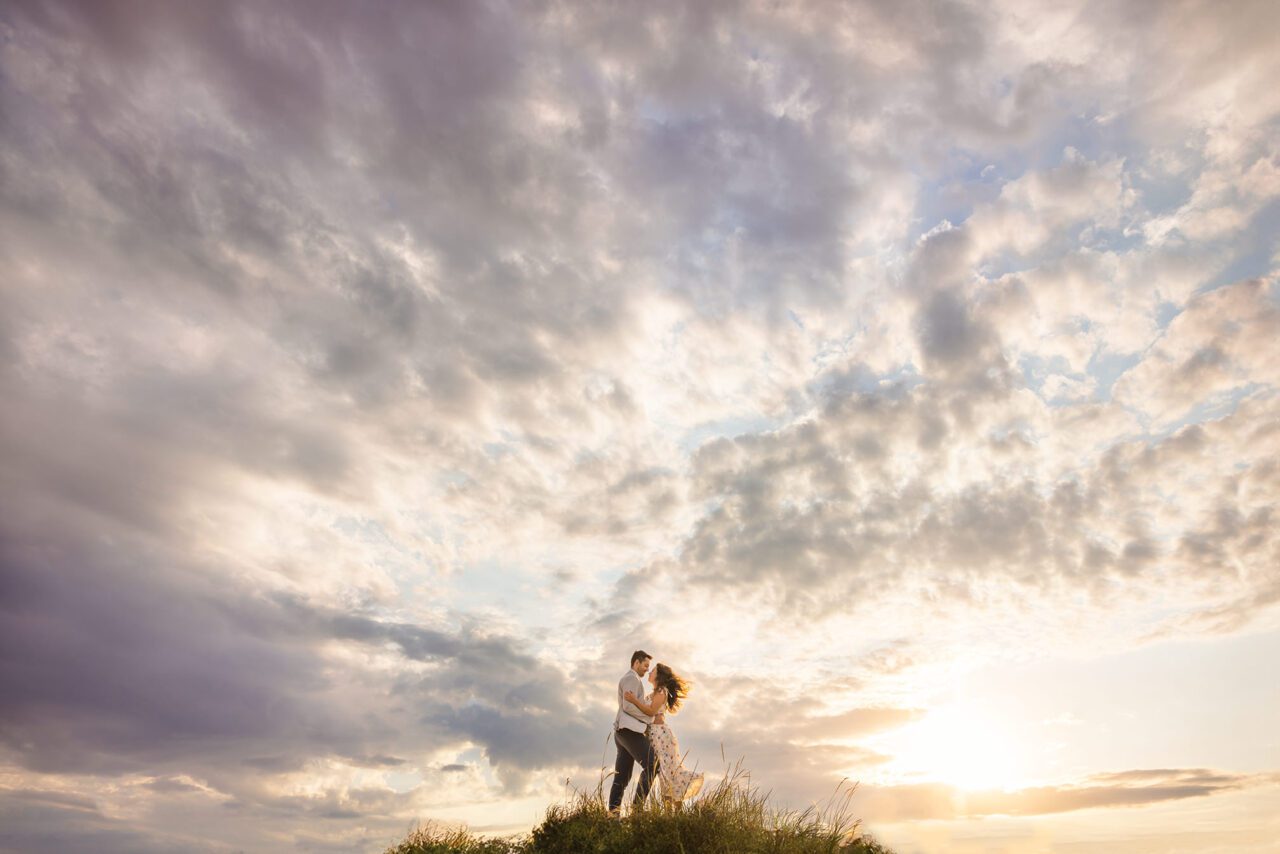 couple on sand dune at sunset