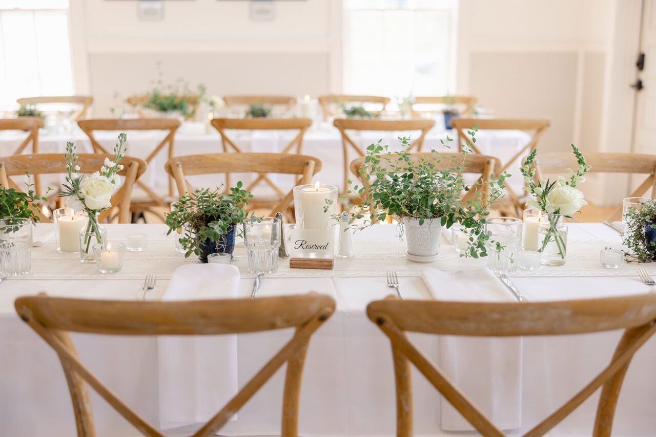 white farm tables with simple beautiful candles and green plants