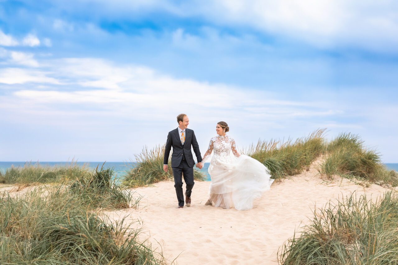 Couple walking the beach at Lake Michigan during their wedding