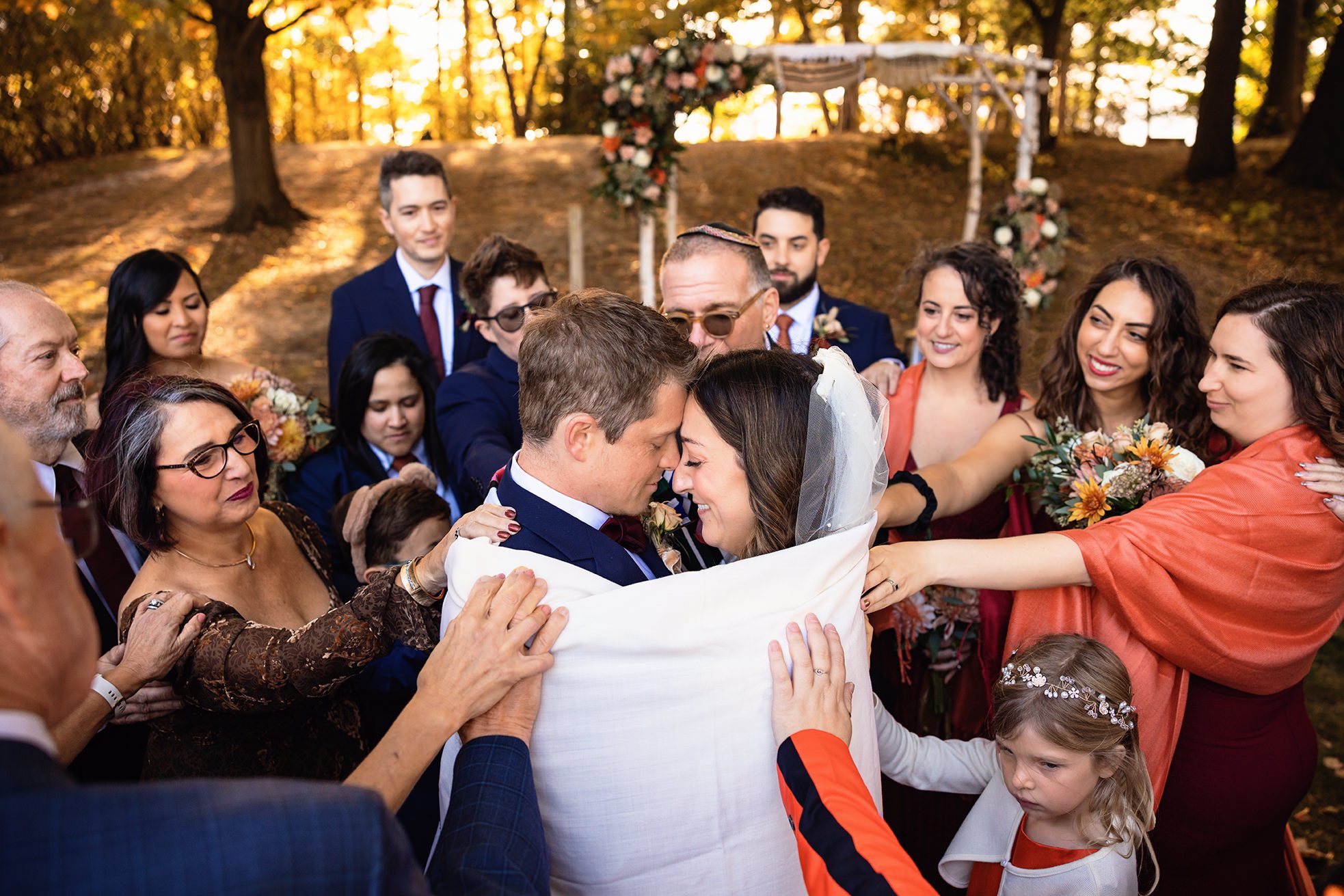 bride and groom being wrapped during jewish ceremony in the fall on old mission peninsula