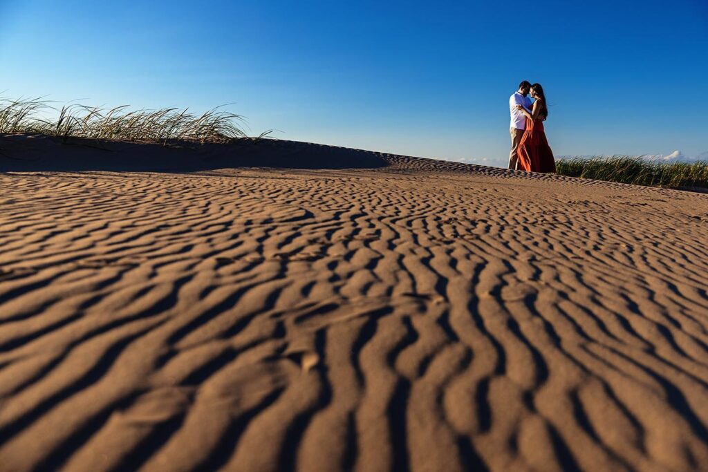 Couple on sand dunes for engagement photos